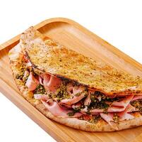 Delicious stuffed flatbread with savory fillings on wooden tray photo