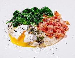 Attractive poached egg with spinach and crispy bacon photo