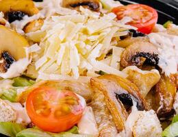 Fresh caesar salad with grilled chicken close-up photo