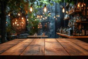 Empty wooden table in front of blurred cafe background with hanging light bulbs photo