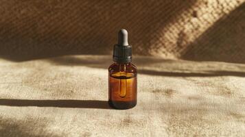 Amber glass dropper bottle with serum on beige textured fabric. Sunlight casts shadows. photo