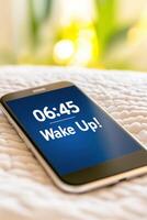 Morning alarm on smartphone displaying wake up notification at 0645 with snooze and dismiss options on cozy bed photo