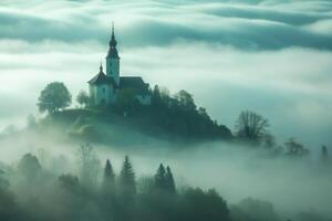 A church on top of a hill surrounded by fog photo