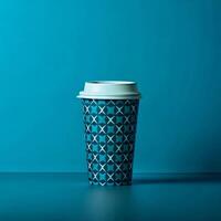 Teal and White patterned coffee cup on a teal background A single takeaway coffee cup sits photo