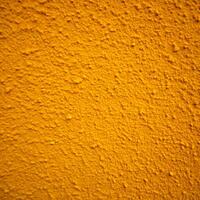 Close Up View of a Deep Yellow Textured Surface Detailed Yellow Wall Texture Background photo