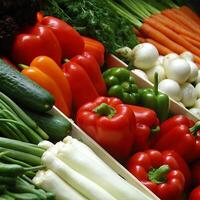 A vibrant display of fresh vegetables at a market featuring red and orange bell peppers, green bell peppers, cucumbers, carrots, onions, leeks photo