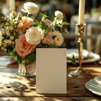 Elegant Wedding Table Setting with White Folded Card on Rustic Table Surrounded by Beautiful Floral Arrangement and Candlelight for Distinctive Celebrations and Events photo