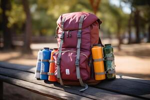 A backpack with several bottles and water bottles on a bench photo