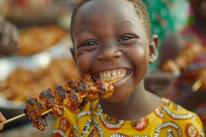 A young boy smiles while holding a skewered skewered meat photo