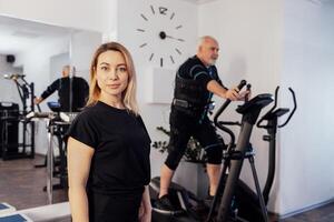 Personal female trainer with her client in ems suit in gym. photo
