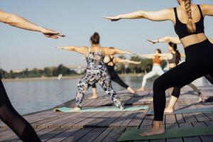 Yoga class with an instructor at the pier on the river photo