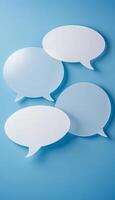 Transparent speech bubbles float against a blue background, visually representing communication and dialogue, perfect for social media and marketing. photo