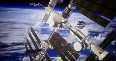 International space station orbits earth against a backdrop of clouds video