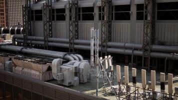 A large group of pipes is seen on the side of a building in a busy cityscape video