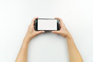 Hands holding up a smartphone with a blank screen photo