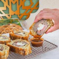 People Hand Dipping Cake Into Sauce with Ramadan and EID Mubarak Theme photo