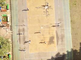 drone shot of Football Game on futsal field. Top view of boys having fun playing football in Cicalengka Square. Playing ball on cement field. Sports Activity photographed from above. photo