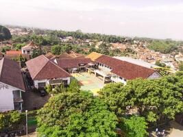 Aerial view of a soccer field in the middle of a brown-roofed building. Drone Landscape of an elite school, photographed from above. Wide angle panoramic photo suitable for web banner