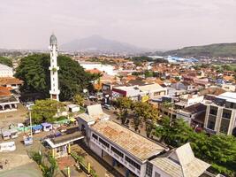 Drone Shot of the main square and the Cicalengka Grand Mosque. Panoramic cityscape landscape from a high angle view of mosque with tower and sports court on Town square. photo