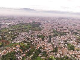 Residential District and Neighborhood in foggy morning. Suburbs of Bandung in West Java, Indonesia, photographed from above. Wide angle panoramic photo suitable for web banners