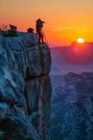 A photographer is taking pictures of the sunset on a mountain photo