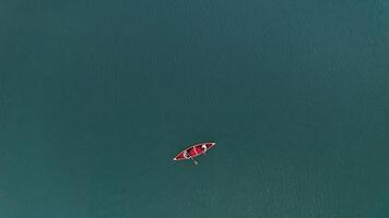 An aerial view of a red boat floating in the water photo