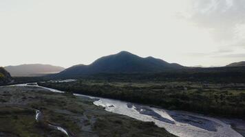 A river runs through a valley with mountains in the background photo