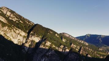 A mountain range with green trees and a blue sky photo