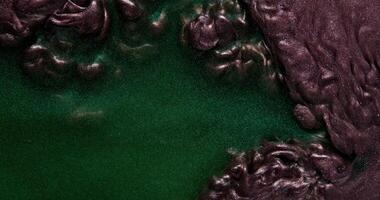Two dark glitter paint blend actively gurgle and create abstract patterns photo