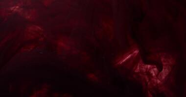 A close up of a red liquid flowing over a black background photo
