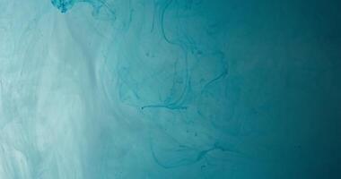 A blue liquid is flowing in a dark room photo