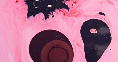 A pink liquid with black and white paint photo