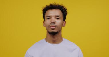 A young man in a white t - shirt against a yellow background photo