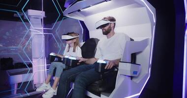 Two people in vr headsets sitting in a chair photo