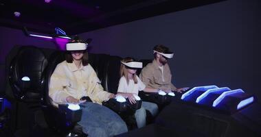 Three people wearing virtual reality headsets in a dark room photo