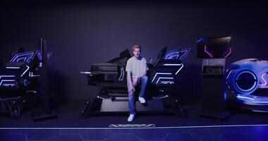 A man sitting on a chair in front of a large gaming machine photo