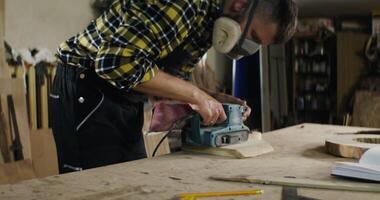 A man is using a power tool to cut wood photo