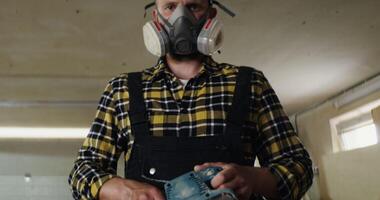 A man wearing a gas mask and holding a saw photo