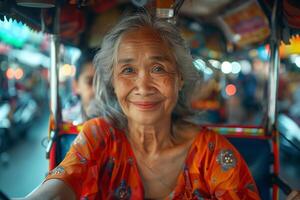 An older woman smiles while riding a tuk tuk photo