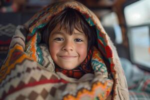 A young boy is wrapped up in a blanket photo