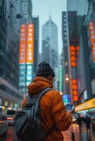 A man in an orange jacket is looking at his phone photo