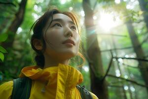 A woman in a yellow raincoat looking up at the sun photo