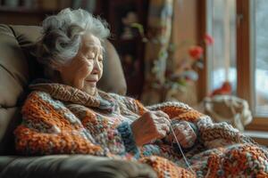 An elderly woman is sitting in a chair and knitting photo