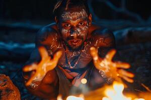 A man with painted face sitting in front of a fire photo