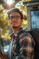 A man with glasses and a backpack standing in front of a bus photo