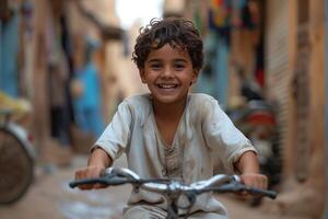 A young boy smiles while riding a bicycle in a small alley photo