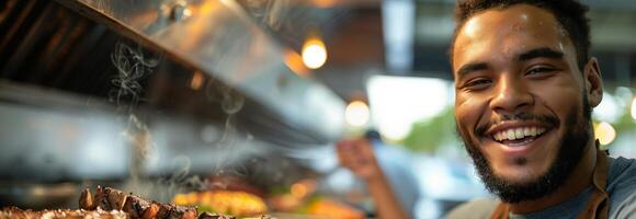 A smiling man is standing in front of a grill photo