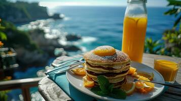 A stack of pancakes on a plate with orange juice and a glass of orange juice photo
