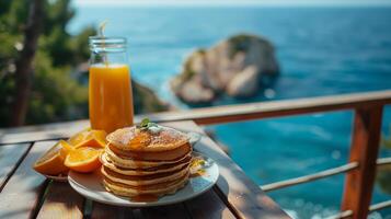 A stack of pancakes on a table with orange juice photo