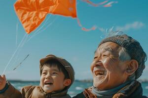 An older man and a young boy are flying a kite photo